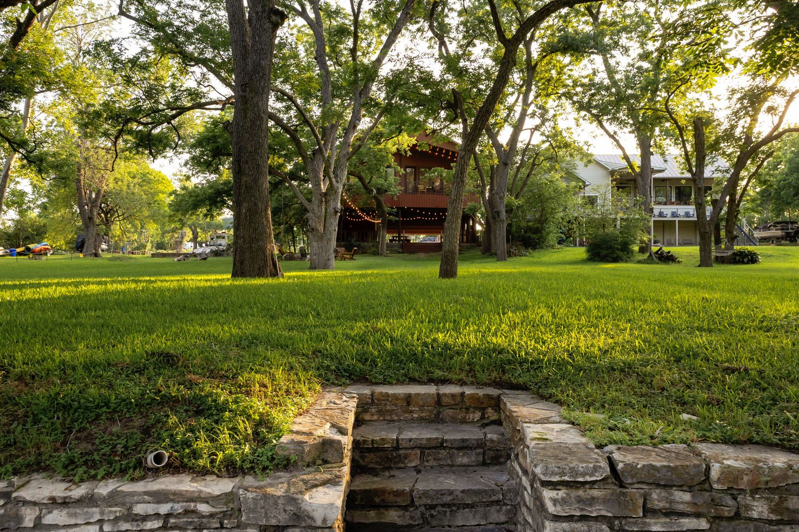 Park-like lawn and mature trees between the lodge and lake